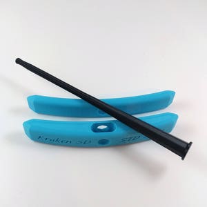 Puede incluir: Dos desmontadores de neumáticos de plástico azul con el texto "Kraken 3D STD" impreso en uno de ellos. Un desmontador de neumáticos negro está colocado sobre los desmontadores.