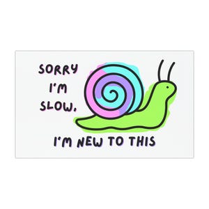 May include: A rectangular white sticker with a cartoon snail illustration. The snail has a green body, a multi-colored shell, and black antennae. Text reads "SORRY I'M SLOW, I'M NEW TO THIS" in black and purple.