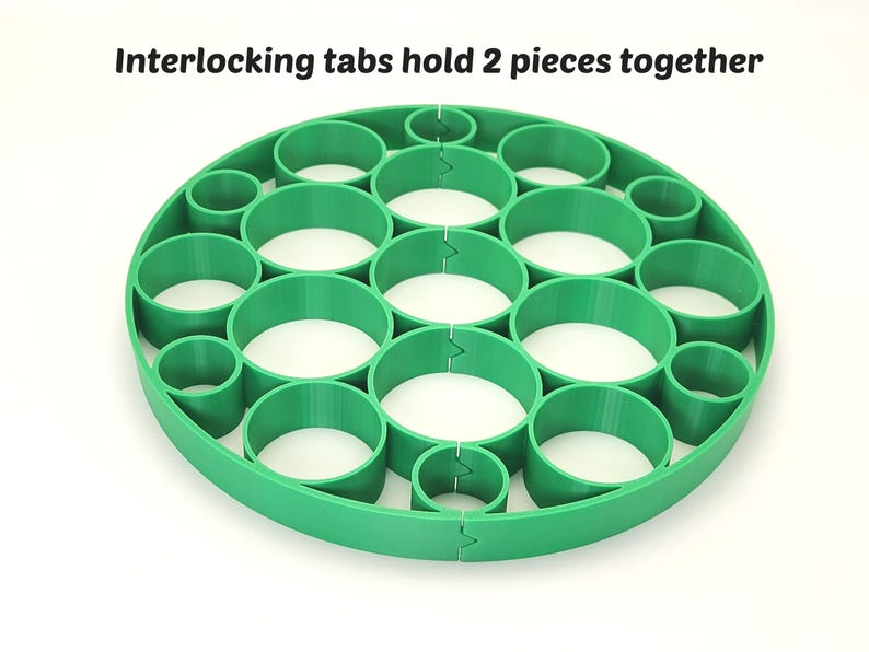 May include: A bright green, circular object with multiple cylindrical openings. The text "Interlocking tabs hold 2 pieces together" is printed at the top. The design features interlocking tabs to hold two pieces together.
