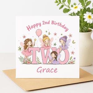 Może przedstawiać: Kwadratowa kartka z życzeniami z napisem "Happy 2nd Birthday" i imieniem "Grace". Karta zawiera ilustracje wróżek, słowo "TWO", różowy balon i kwiatowe akcenty. Karta leży na brązowej kopercie.