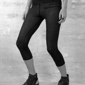 May include: Black cropped leggings with a wide waistband. The leggings are made of a soft, stretchy fabric and are perfect for yoga, running, or everyday wear.