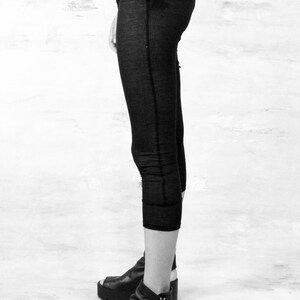 May include: Black cropped leggings with a small V logo on the front. The leggings are worn with black platform sandals.