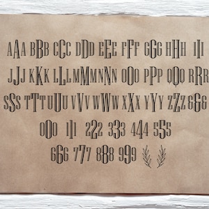 May include: A printed sheet of paper with black uppercase letters and numbers in a decorative font. The letters range from A to Z, and the numbers are from 0 to 9. The paper has a brown, aged appearance.