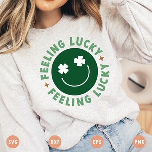May include: A gray sweatshirt with a green circle design that says "Feeling Lucky Feeling Lucky" with a green smiley face and shamrock eyes.