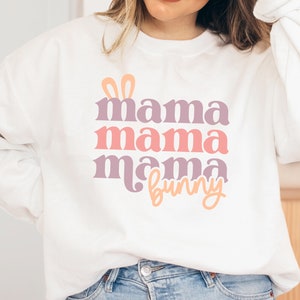 May include: White sweatshirt with a pink, purple, and orange graphic that says "mama mama mama bunny" with bunny ears above the text.
