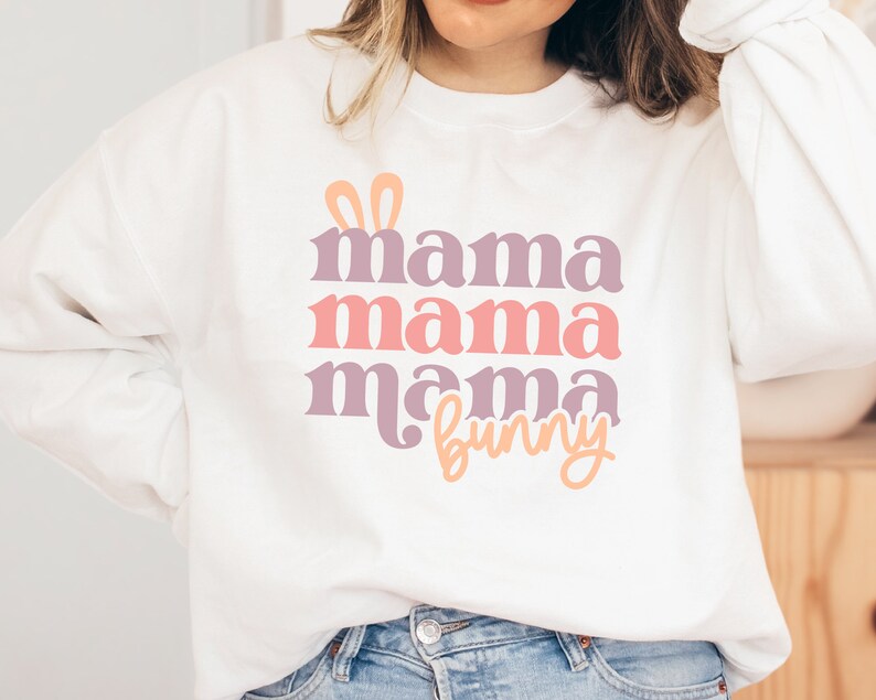 May include: White sweatshirt with a pink, purple, and orange graphic that says "mama mama mama bunny" with bunny ears above the text.