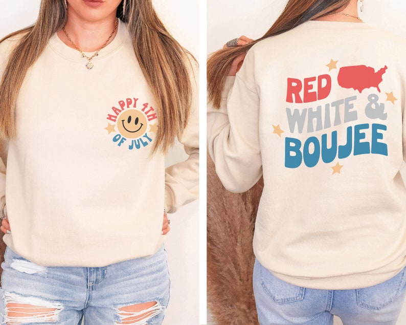 May include: A cream-coloured sweatshirt with a red, white and blue smiley face graphic on the front that says "Happy 4th of July". The back of the sweatshirt has a red, white and blue graphic that says "Red White & Boujee" with a small outline of the United States.