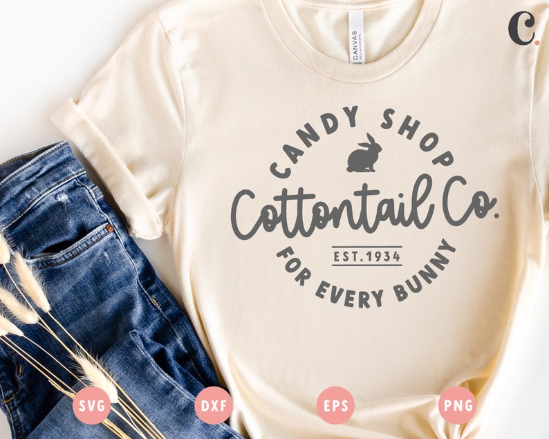 May include: A beige t-shirt with a gray circle design that says "Candy Shop Cottontail Co. Est. 1934 For Every Bunny". The design also includes a silhouette of a rabbit.