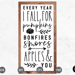 Op de afbeelding: Een zwart-wit bord met de tekst "EVERY YEAR I FALL FOR pumpkins BONFIRES S'mores APPLES & YOU". Het bord is ingelijst met hout en heeft een pompoenafbeelding.