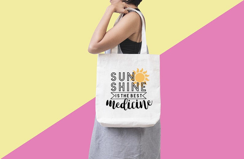 May include: White tote bag with black text that reads "Sunshine is the best medicine" and a yellow sun graphic.