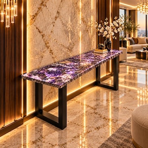 Può includere: Un tavolo console rettangolare con una superficie in ametista viola lucida dalla texture cristallina naturale, sostenuto da una robusta struttura in metallo nero con due gambe a forma di U, posizionato contro una parete in marmo retroilluminata.