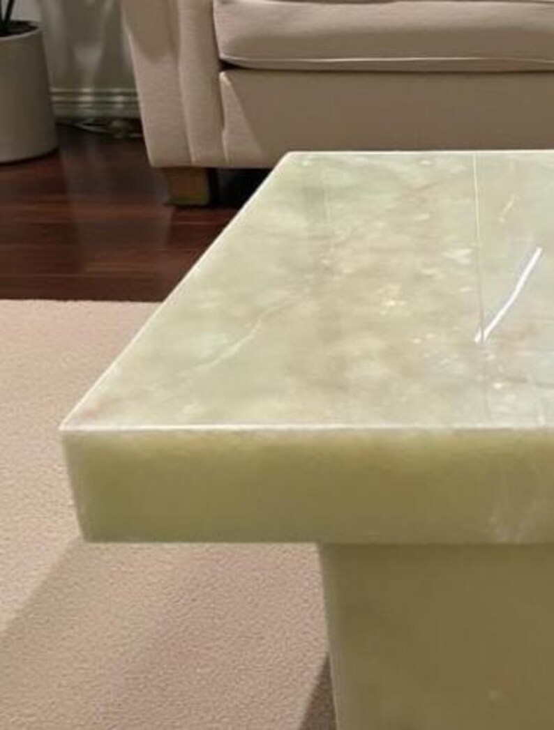 Puede incluir: Una mesa de centro rectangular verde claro con un patr&oacute;n similar al m&aacute;rmol. La mesa tiene una base s&oacute;lida y una superficie lisa y pulida. La mesa est&aacute; hecha de un material s&oacute;lido y es adecuada para una sala de estar.