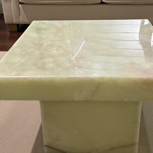 Rectangular onyx slab coffee table with a minimalist plinth stand design, highlighting natural stone elegance