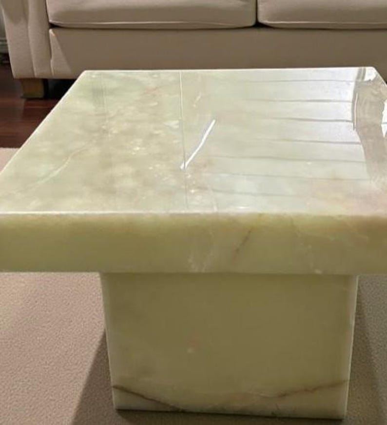 Rectangular onyx slab coffee table with a minimalist plinth stand design, highlighting natural stone elegance