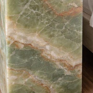 Luxury plinth accent table placed next to modern bed