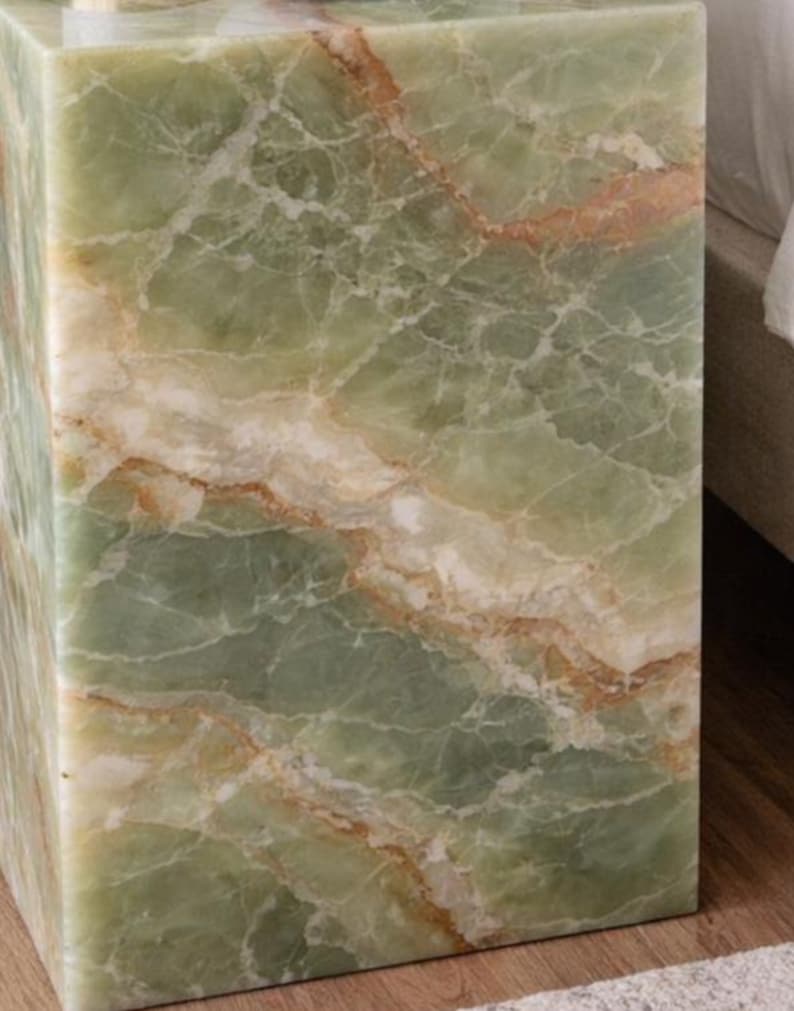 Luxury plinth accent table placed next to modern bed