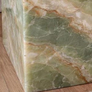 Premium green onyx accent table beside upholstered bed