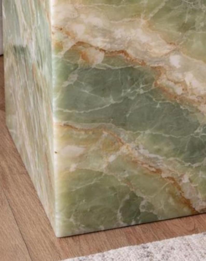 Premium green onyx accent table beside upholstered bed