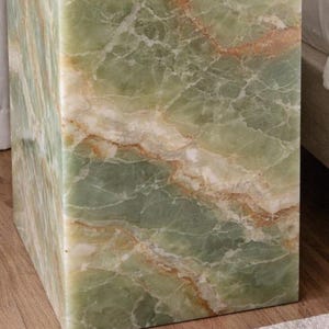 Polished green onyx cube table in elegant bedroom interior
