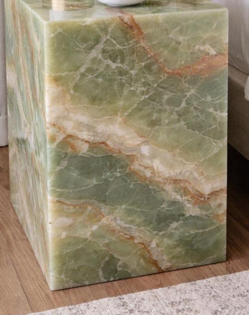 Polished green onyx cube table in elegant bedroom interior
