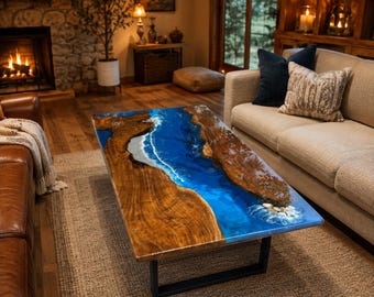 May include: A rectangular coffee table featuring a live edge wood slab with a central river design made of translucent blue resin. The resin includes white swirling patterns resembling ocean waves. The table has a black metal frame base.