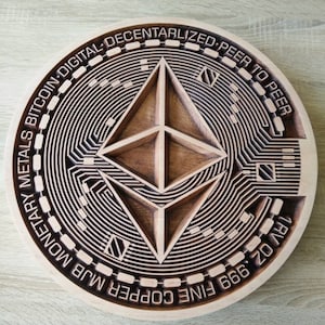 Pode incluir: Uma placa redonda de madeira com um design de corte a laser do logotipo da criptomoeda Ethereum. A placa tem o texto "FINE COPPER 999 MJB 1/2 OZ. 1RV 0Z. BITCOIN DIGITAL DECENTRALIZED PEER TO PEER MONETARY METALS" ao redor da borda.