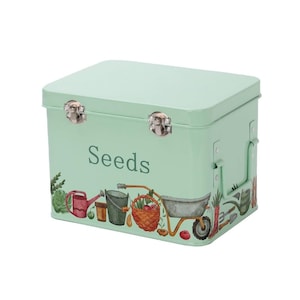 May include: A light green metal storage box with a hinged lid and two clasps. The box has a white label that says "Seeds" and a colourful illustration of gardening tools and plants.