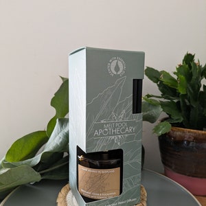Peut inclure: Une boîte verte et blanche avec le texte "Melt Pool Apothecary" et "Diffuseur de roseaux naturellement parfumé". La boîte contient une bouteille en verre brun avec une étiquette qui indique "Bergamote, clou de girofle et eucalyptus parfumé aux huiles essentielles".