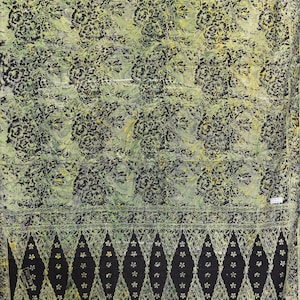 May include: A green and black batik fabric with a floral pattern. The fabric has a border of black and white diamonds with a floral design.