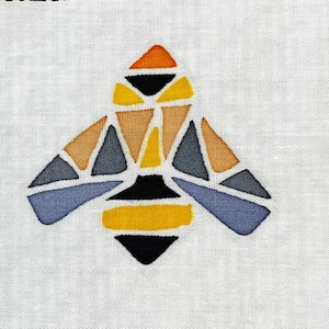 May include: Geometric bee design in shades of orange, yellow, brown, gray, and black on a white fabric background.