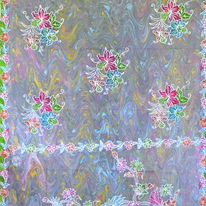 May include: A gray textile with a swirling pattern and floral designs. The fabric features repeating clusters of flowers in pink, blue, and green, outlined in white. A border of flowers in various colors frames the edges.