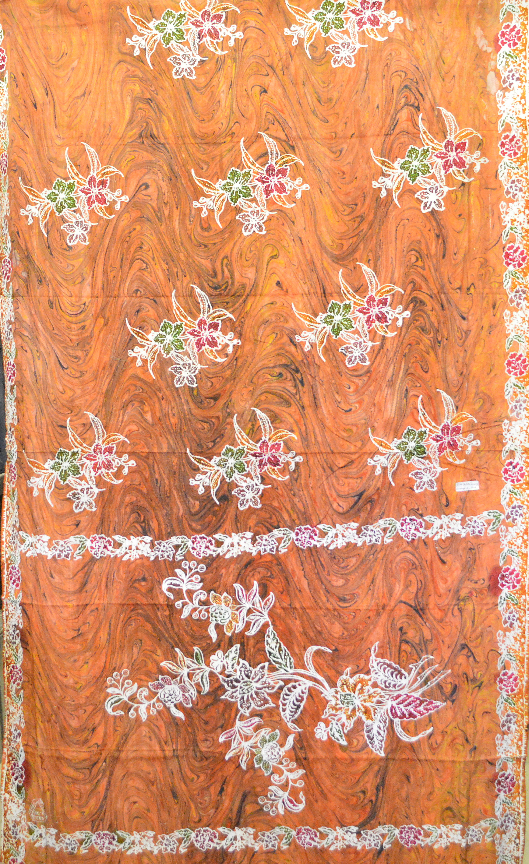 May include: Orange fabric with a white and brown marbled pattern and a white floral design. The fabric has a white border with a small floral design.