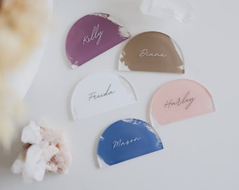 May include: Five acrylic place cards with brushstroke designs in various colors. The names "Kelly", "Diana", "Freida", "Harley", and "Mason" are written in white script on the cards.