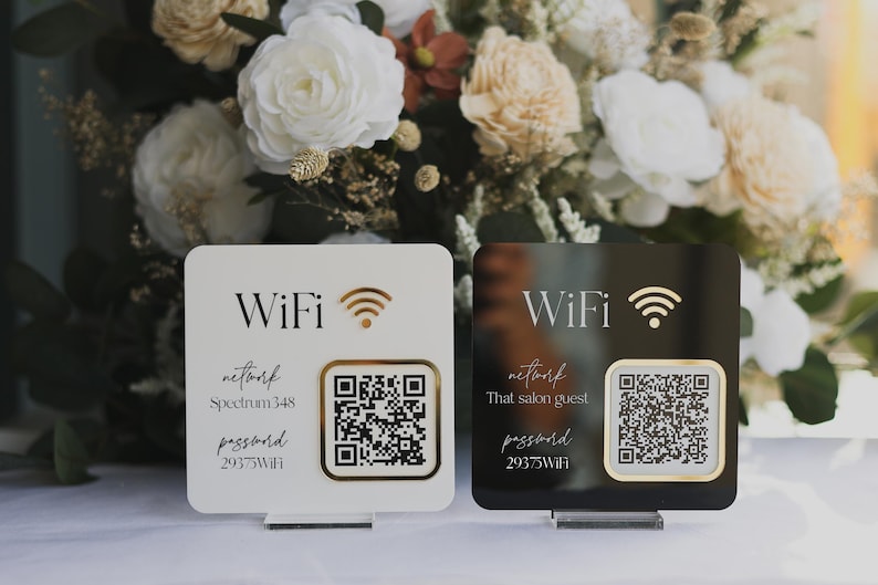 May include: Two square WiFi signs, one white and one black, with gold accents. Each sign displays "WiFi", a signal icon, a QR code, and network information. The white sign reads "Spectrum 348" and the black sign reads "That salon guest".