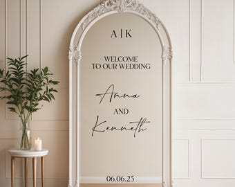 May include: White ornate mirror with a welcome sign for a wedding. The sign reads "Welcome to our wedding, Anna and Kenneth, 06.06.25".