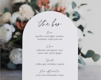 May include: White arch-shaped sign with the text "the bar" in black script. The sign lists various alcoholic and non-alcoholic beverages, including beer, wine, spirits, and non-alcoholic options like coca-cola, lemonade, and water.