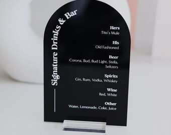 May include: Black acrylic arch sign with white text listing signature drinks and bar options. The sign reads "Signature Drinks & Bar" at the top and lists drink options like "Hers", "His", "Beer", "Spirits", "Wine", and "Other".
