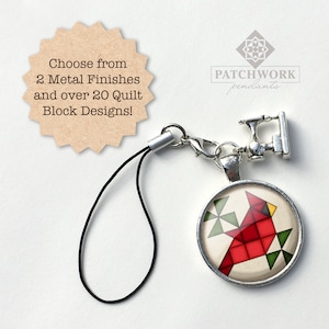 May include: A red cardinal quilt block charm with a black cord and a silver charm of a sewing machine. The charm is attached to a silver clasp. The charm is labeled "Patchwork pendants".