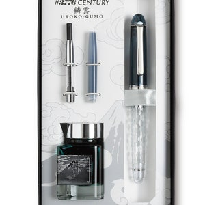 May include: A black and silver fountain pen with a clear, textured barrel. The pen is in a box with a bottle of ink and two cartridges. The box has a white background with a mountain design and the text "#3776 CENTURY 鱗雲 UROKO-GUMO".
