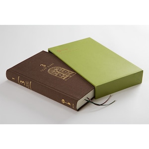 Puede incluir: Un diario de tapa dura marrón con letras doradas que dicen "3 Year Diary". El diario está cerrado y tiene un diseño de llave dorada en la portada. El diario está en una caja verde.