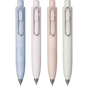 May include: Set of four pens with a speckled finish in blue, white, pink, and grey. Each pen has a silver clip and a silver tip.
