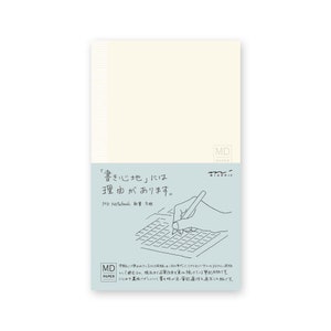 Könnte beinhalten: Ein weißes Notizbuch mit einem Rastermuster und dem Text "MD Paper" und "Midori" in Schwarz. Der Text "'Schreiben' hat einen Grund." ist in Schwarz und japanischen Schriftzeichen. Eine Hand hält einen Stift und schreibt in das Notizbuch.