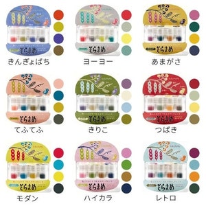 Könnte beinhalten: Ein Set mit 10 Aquarellfarben-Sets, jedes mit einem anderen Farbschema und einem japanischen Namen. Die Farbsets sind in einem Raster von 3 Reihen und 4 Spalten angeordnet. Die Namen der Farbsets sind: Kin Gyo Bachi, Yo Yo, Ama Gasa, Te Fu Te Fu, Kiri Ko, Tsu Baki, Mo Dan, Hai Ka Ra und Re To.