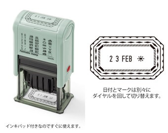 May include: A green and white self-inking stamp with a date and symbol dial. The stamp is labeled "Paintable Stamp" and has a dial with the months of the year and symbols like a star, sun, and cloud. The stamp is set to "01 JAN 90" and the dial is set to "2 3 FEB" with a sun symbol.