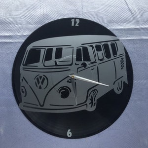 Peut inclure: Une horloge en vinyle noir avec une silhouette grise d'un van Volkswagen. Le cadran de l'horloge comporte les chiffres 12 et 6.