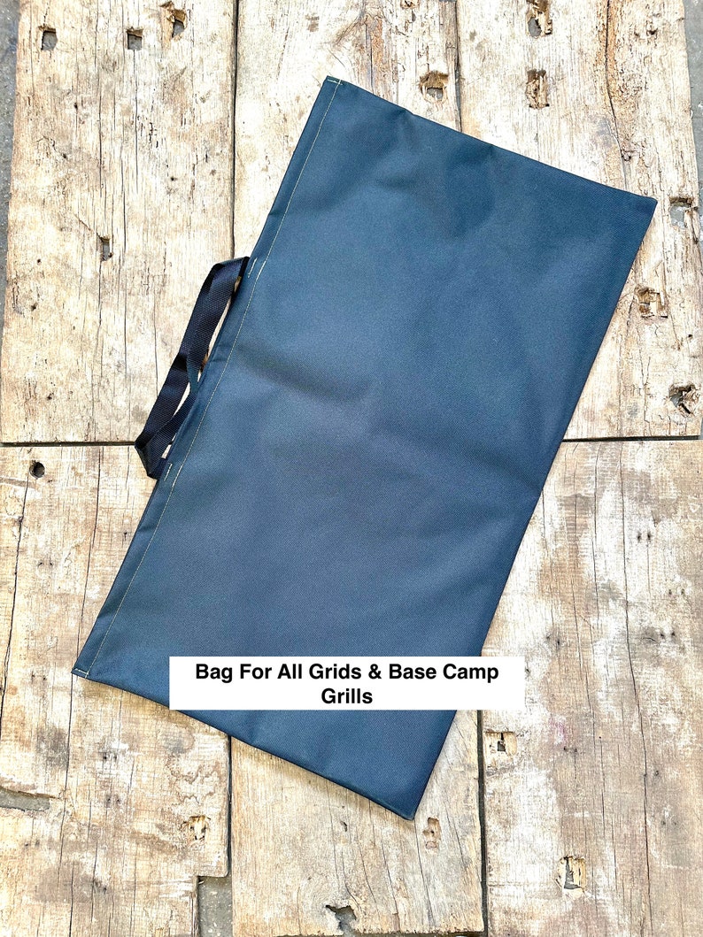 Pode incluir: Uma bolsa de lona azul escura com al&ccedil;as pretas e o texto "Bag For All Grids & Base Camp Grills" impresso na frente.