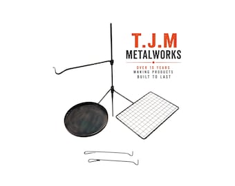 May include: A black metal campfire cooking system featuring a vertical pole, a circular pan, a rectangular grid, a hook arm, and two separate metal handles. The text T.J.M METALWORKS OVER 10 YEARS MAKING PRODUCTS BUILT TO LAST is visible.