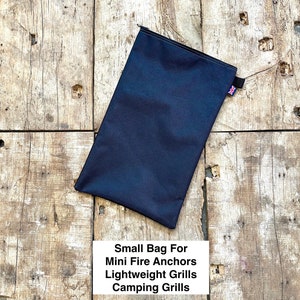 Peut inclure: Un sac en toile noir avec une fermeture éclair et un petit drapeau britannique cousu sur le côté. Le sac est étiqueté "Small Bag For Mini Fire Anchors Lightweight Grills Camping Grills".