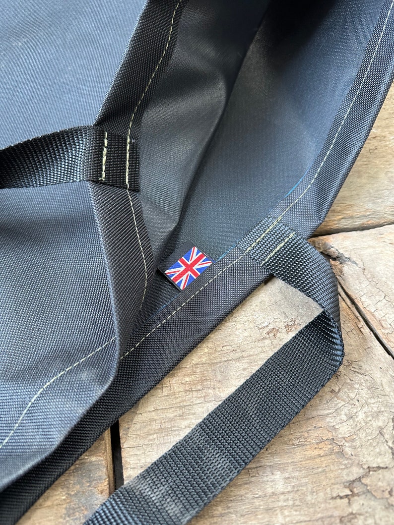 Pode incluir: Uma bolsa tote preta com uma bandeira do Reino Unido bordada na frente. A bolsa tem duas al&ccedil;as pretas e &eacute; feita de um tecido resistente.