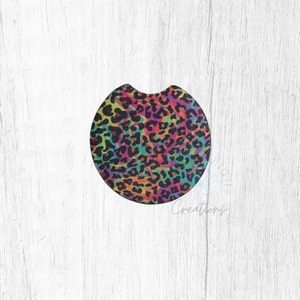 May include: Round car coaster with a colorful leopard print design. The print features a rainbow of colors including pink, orange, yellow, green, blue, and purple. The background is black.